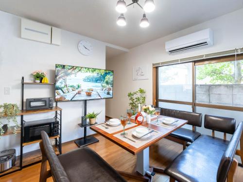a dining room with a table and chairs at 海街ゲストハウス in Takamatsu