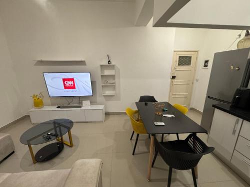 a living room with a table and a tv at Apartamento 1 Quarto - Baixa de Luanda in Luanda