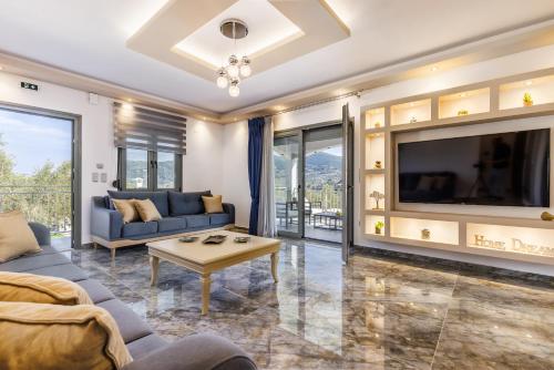 a living room with a large tv and a couch at Luxury VILLA RAFAEL in Skopelos Town