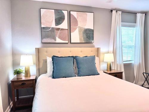 a bedroom with a white bed with blue pillows at Restful Retreat with 4 Beds Sleeps 6 in Valdosta