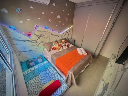a small bedroom with a bed and a wall with planets at Sua casa em pdetorres in Passo De Torres