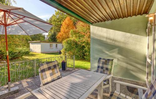 a patio with a table and chairs and an umbrella at Ferienhaus Boitzenburger Land in Rosenow