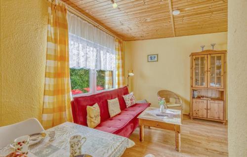 a living room with a red couch and a table at Ferienhaus Boitzenburger Land in Rosenow