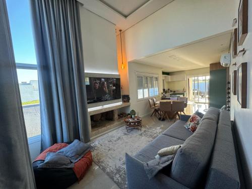 a living room with a blue couch and a tv at Sua casa em pdetorres in Passo De Torres