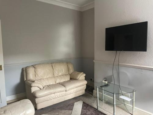 a living room with a couch and a flat screen tv at Modern Double Rooms Near Stoke City Centre and Staffordshire Uni in Stoke on Trent