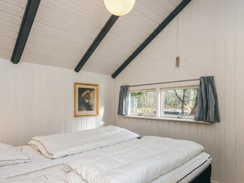 een witte kamer met een bed en een raam bij Secluded Haven in Rindby in Fanø