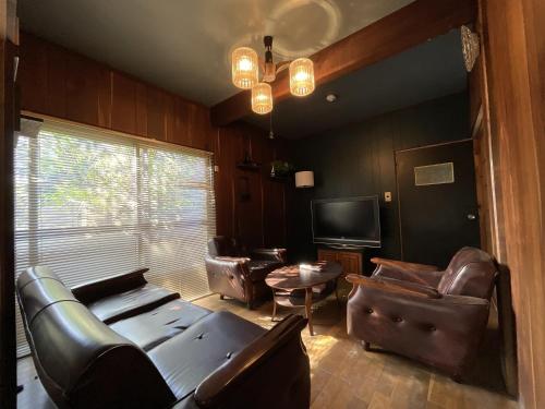 Ōwadaにある美淡-Mitan-の革張りの家具と薄型テレビを備えたリビングルーム