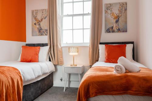 WrittleにあるGrace Bartlett House for 5 with Free Parking for 2のオレンジと白の部屋のベッド2台