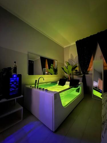 a bathroom with a green bathtub with a sink at TROPICAL RHAPSODY - Jacuzzi & King Size a Torino Centro in Turin