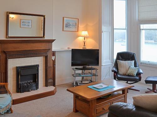 een woonkamer met open haard en tv bij Waterside in Fowey