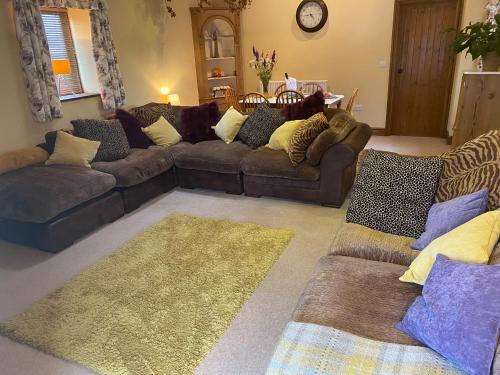 a living room with couches and a rug at Lily Rose Cottage in Lanercost