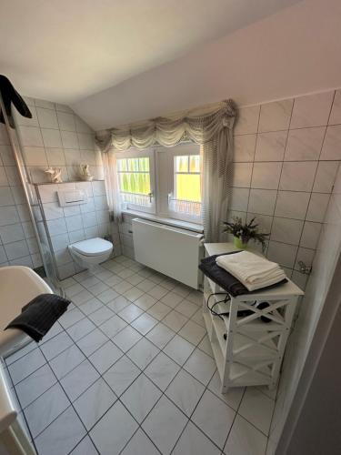 Un baño con bañera, inodoro y ventana. en Haus Inseltraum, en Fehmarn