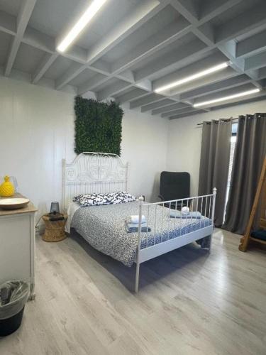 a bedroom with a white bed and a green wall at Fenais da Luz House in Fenais da Luz