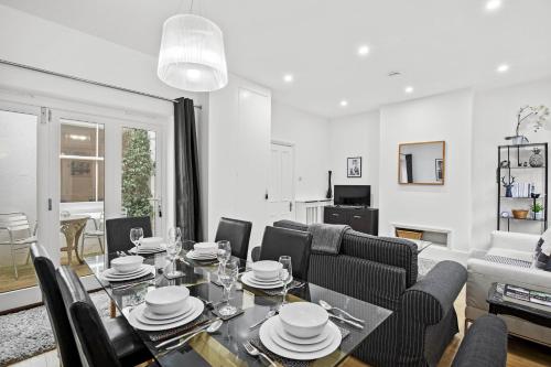 a dining room and living room with a table and chairs at The Coastal Den By My Getaways in Brighton & Hove