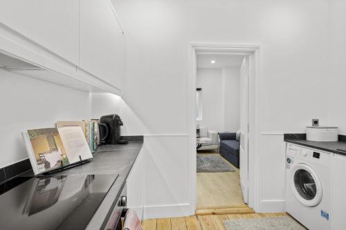 a white laundry room with a washer and dryer at The Coastal Den By My Getaways in Brighton & Hove