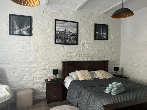 ein Schlafzimmer mit einem Bett und einer weißen Ziegelwand in der Unterkunft Zacisze Krasińskiego in Toruń
