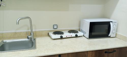 eine Mikrowelle auf einer Küchentheke neben einer Spüle in der Unterkunft Résidence touristique marcadal by Mon rêve in Fort de lʼEau