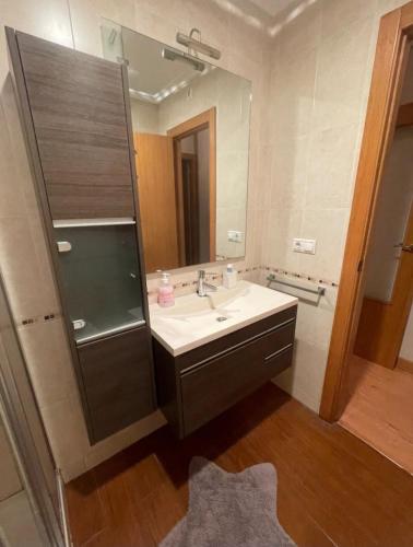 a bathroom with a sink and a large mirror at Apartamento céntrico in Elche