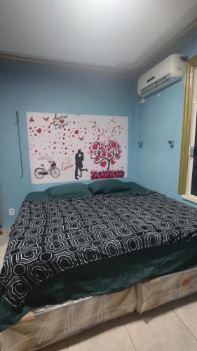 ein Schlafzimmer mit einem Bett mit einer schwarz-weißen Bettdecke in der Unterkunft Quarto Suíte Parque Dez in Manaus