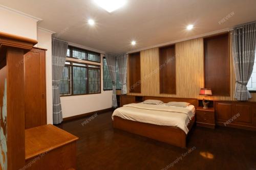 ein Schlafzimmer mit einem Bett und einigen Fenstern in der Unterkunft Villa Le Misk in Batureo 1