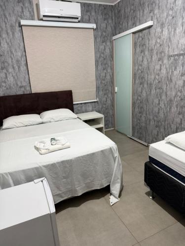a bedroom with a bed with a towel on it at Hotel Life Ijui in Ijuí