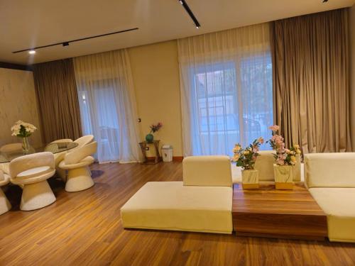 un salon avec des meubles blancs et une grande fenêtre dans l'établissement Velora 4 BR Villa With pool and waterfall in New Cairo, au Caire