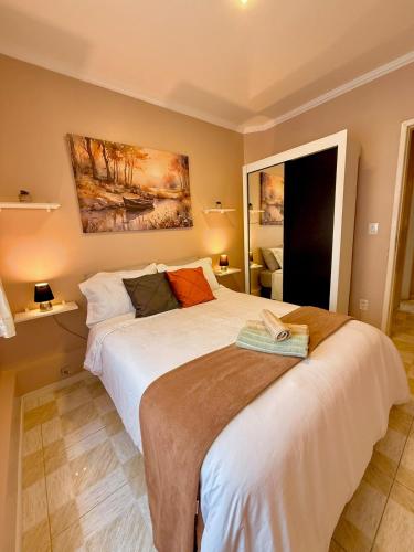a bedroom with a large white bed in a room at Apto 2 dorm Centro de Capão 3 quadras do Mar box e churrasqueira in Capão da Canoa