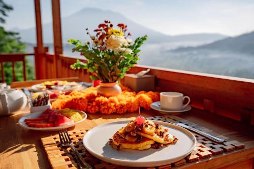 une table sur laquelle sont posées des assiettes de nourriture dans l'établissement Pitak Hill Villa Sidemen, à Sidemen