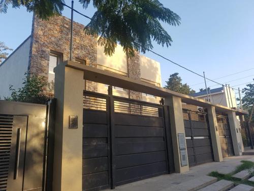 a house with black garage doors on a street at Duplex en City Bell in City Bell