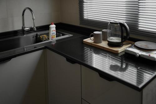 a kitchen counter with a sink and a counter top with a counter at Cozy Apartment in Boshar in Muscat