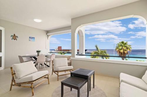 a living room with a view of the ocean at The Shores 3 with sea views beautiful sunsets and a breezy balcony in Kralendijk