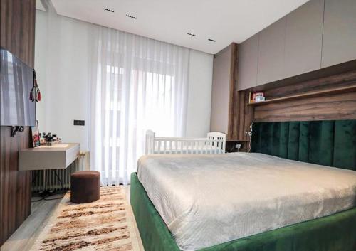 a bedroom with a large bed and a sink at Apartament Modern in Kosovo Polje