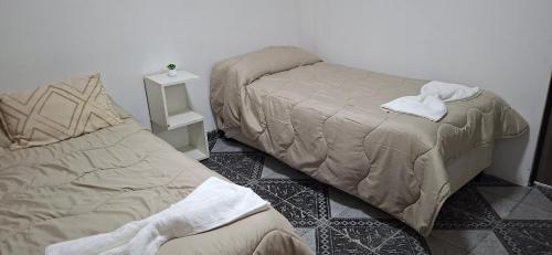 a bedroom with two beds and a night stand at Apart Brumato in Catriel