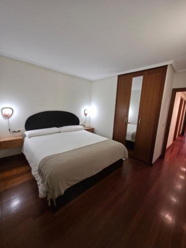 a bedroom with a large bed and a wooden floor at Beach Big Apartment With 3 Rooms Apartment Parking Included in San Sebastián