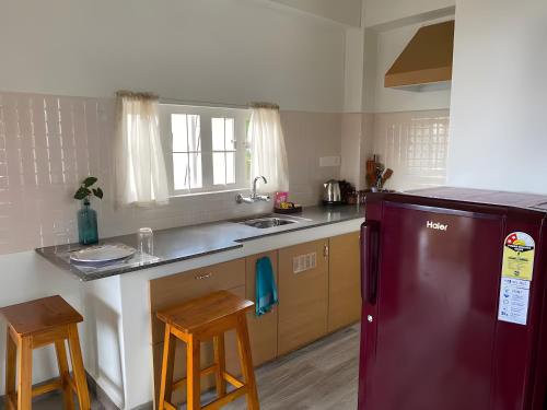 西隆Mid Hill Cottage Guest Suites Nongrim的厨房配有红色冰箱和水槽