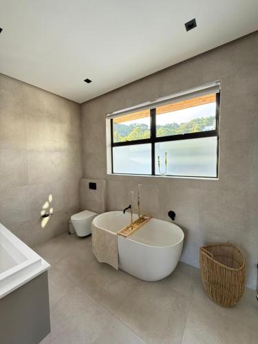 a bathroom with a tub and a sink and a toilet at Views on August - Penthouse Unit 9 in Cape Town