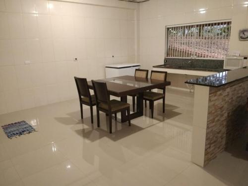 a dining room with a table and chairs at Chácara Amorim in Mairiporã