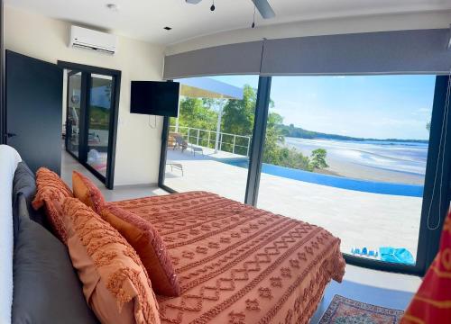 a bedroom with a bed and a large glass window at Villa Sea La Vie in Boca Chica