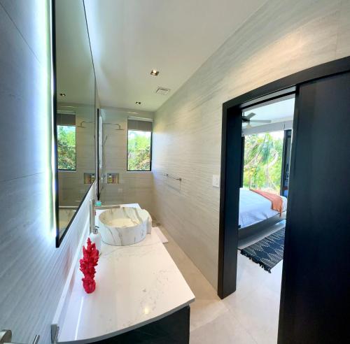 a bathroom with a sink and a bed and a mirror at Villa Sea La Vie in Boca Chica