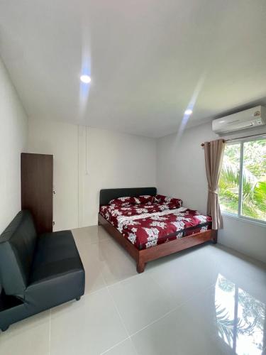 a bedroom with a bed and a couch and a window at Palm tree garden house NinemintoAonangbeach in Ao Nam Mao