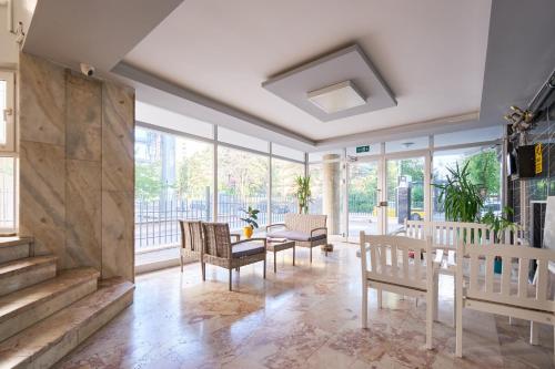 a living room with chairs and a table and windows at Kaira Homes 2 in Ankara