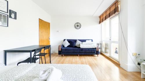 a room with a bed and a blue couch at Central London rooms EC1V in London