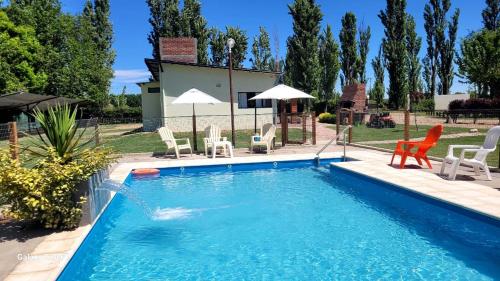 a pool with chairs and umbrellas in a yard at Aires de Primavera in San Rafael