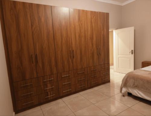 a large wooden cabinet in a bedroom with a bed at The Mining Station in Randfontein