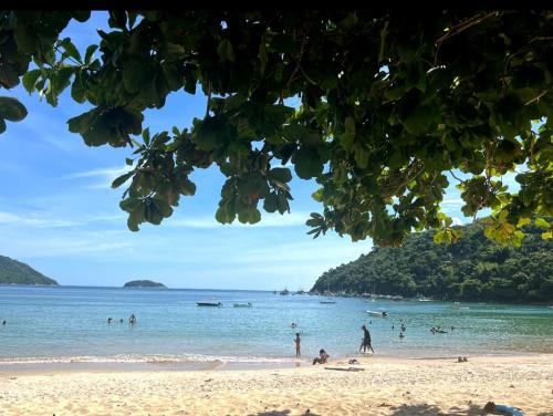 a group of people on a beach in the ocean at casa da Cilene in Angra dos Reis