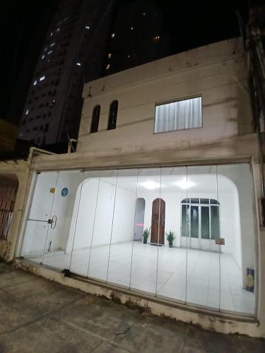 a white building with two windows and two plants at Suite Umarizal cop30 in Belém