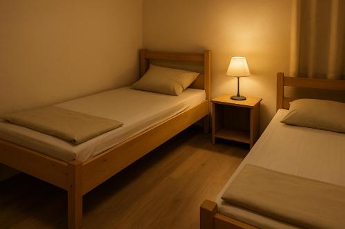 a small bedroom with two beds and a lamp at BB-Miklos in Bockenem