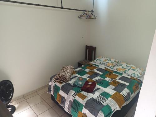 a bedroom with a bed with a quilt on it at Pousada Praia Grande Apartamento Familiar in Praia Grande