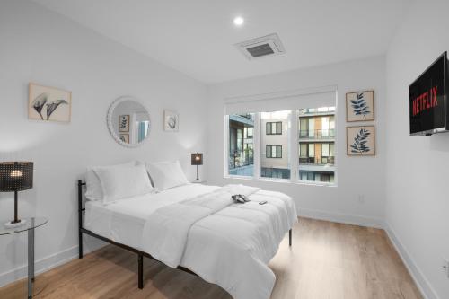 een witte slaapkamer met een groot bed en een raam bij Luxury 1br Getaway - Modern Stylish & Great Area in Philadelphia