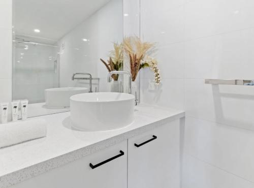 a white bathroom with two sinks and a mirror at Cozy 1-Bed Studio Near Cafes and Shops in Carnegie